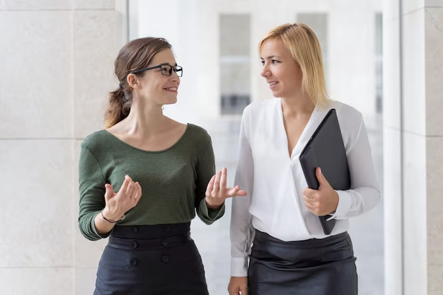 Two women walk side by side and chat